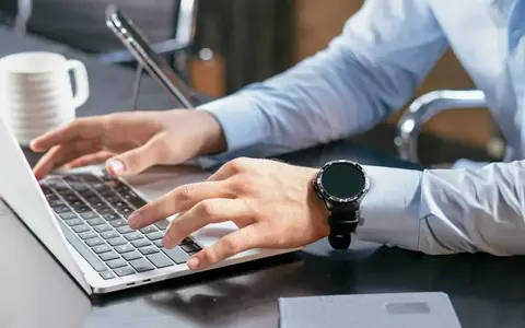 Hands typing on a laptop